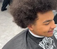 A shaped afro, client smiling in the chair