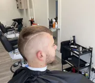 A high skin fade with a shaved hard part and beard